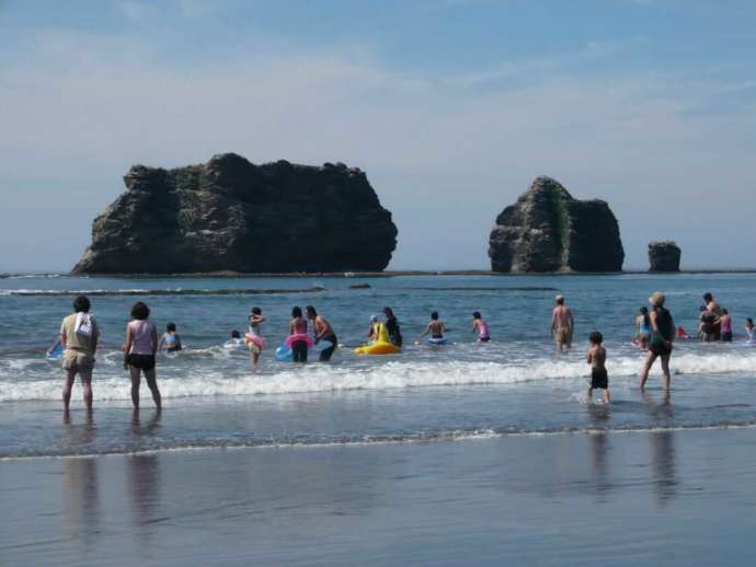 「親子岩ふれ愛ビーチ」で海水浴を楽しむ人々
