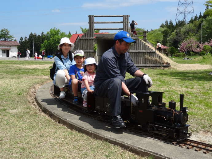 関川村の大石ダム湖畔公園でミニSLに乗る親子