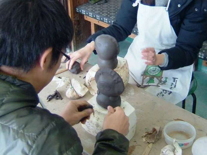 宗陶苑の陶芸体験でたぬきの像を作る体験者