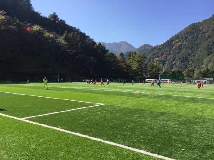 下北山村スポーツ公園のサッカー場でサッカーをする子どもたち