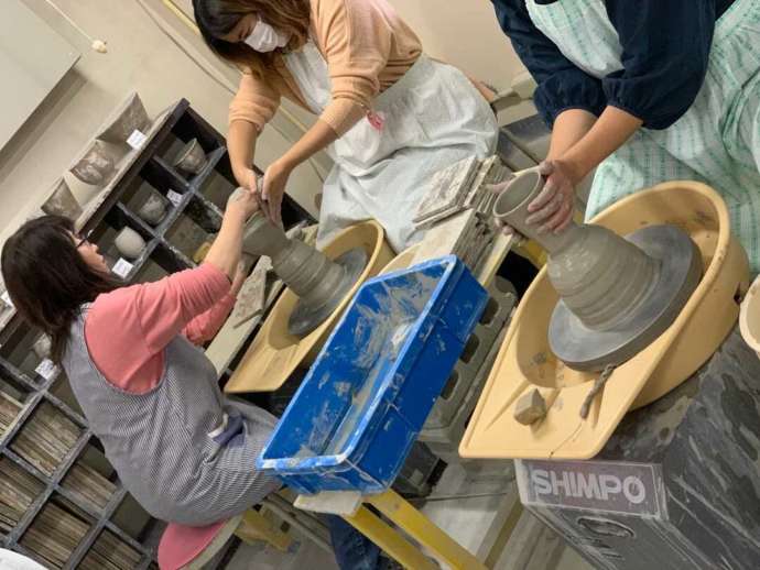 品野陶磁器センター陶芸教室のスタッフがロクロの使い方を教えている様子