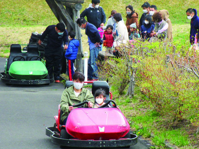 新郷村の「間木ノ平グリーンパーク」のゴーカートに乗る親子