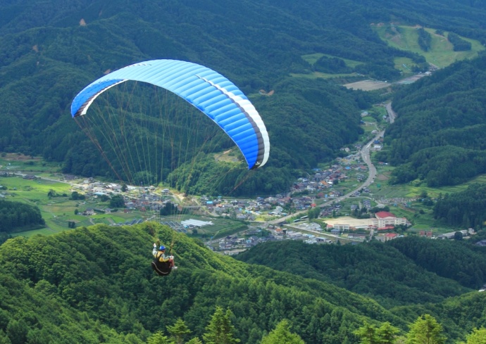 「道の駅 信州平谷」の周りを飛行するパラグライダー