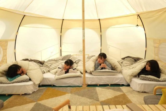 ひるぜん塩釜キャンピングヴィレッジにあるロータスベルテントでベッドに横たわる女性たち
