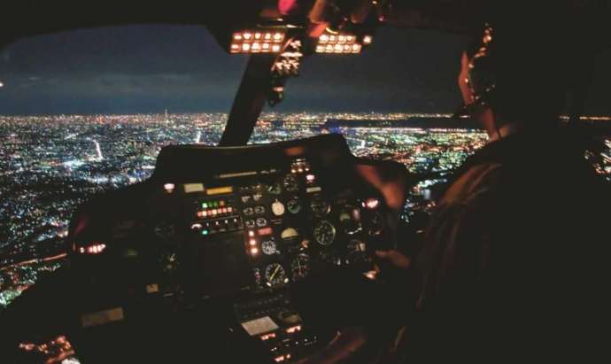 東京都心の上を飛ぶヘリコプターを操縦する機長