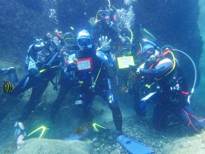 ソットマリノのツアーに参加して海底で記念撮影をする参加者たち