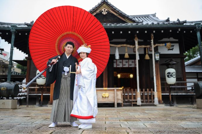 播磨国総社で赤い番傘をさして撮影する新郎新婦