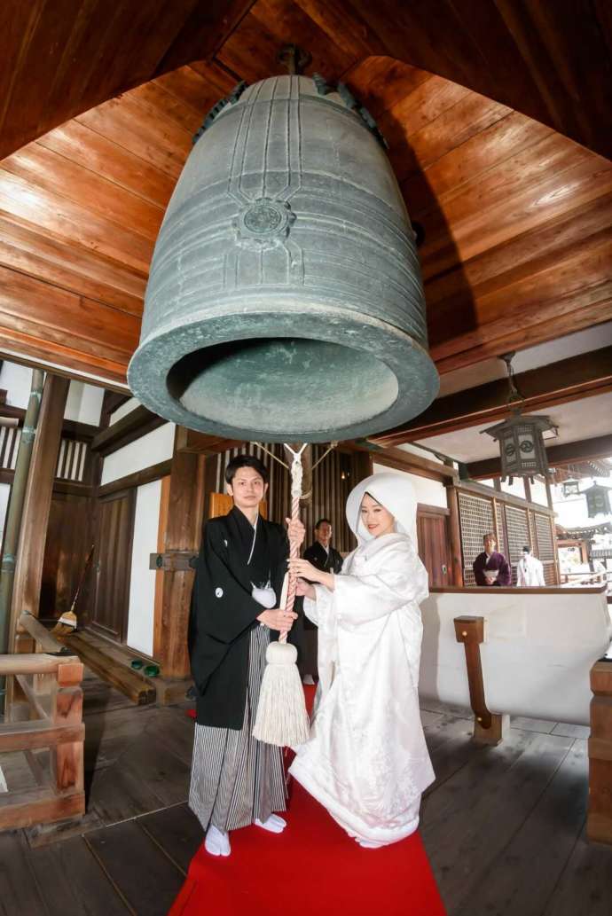 姫路市重要指定文化財の鐘を鳴らす新郎新婦