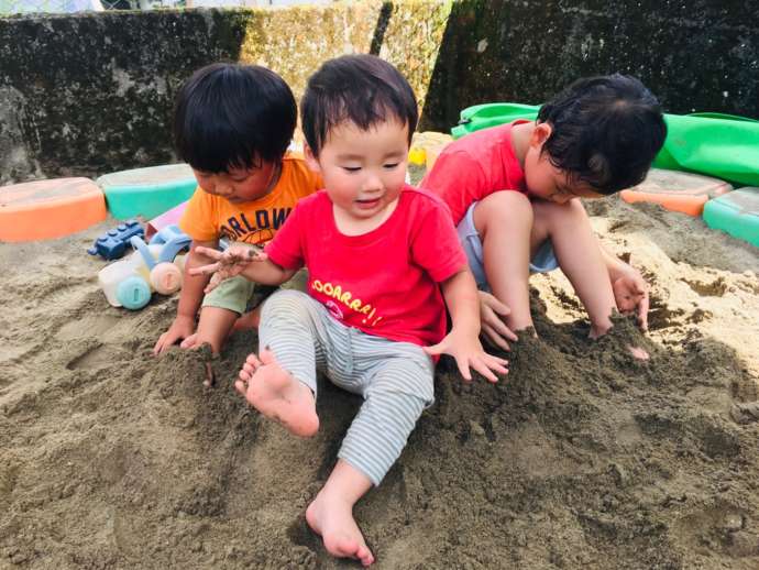 砂場で元気に遊ぶ子ども