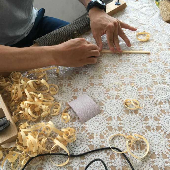 「竹灯籠工房」の体験教室で竹箸を制作中の一コマ（素材を紙ヤスリで研磨中）