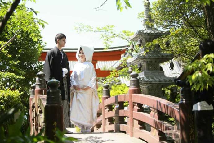 讃岐國一宮田村神社の境内にある橋の上で撮影している新郎新婦