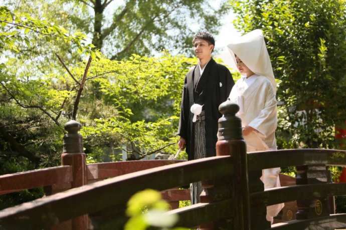 讃岐國一宮田村神社の境内にある橋の上に佇む新郎新婦