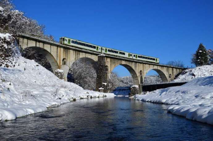 遠野市内を流れる宮守川に架かる半円が五つ連なるJR釜石線「めがね橋」の雪景色