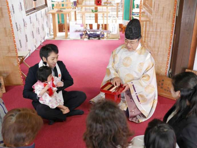 「取手八坂神社」で行う初誕生祭の「選び取り」を説明する様子
