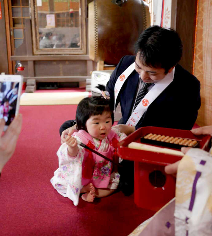 「取手八坂神社」の初誕生祭で「選び取り」を行う祝い子