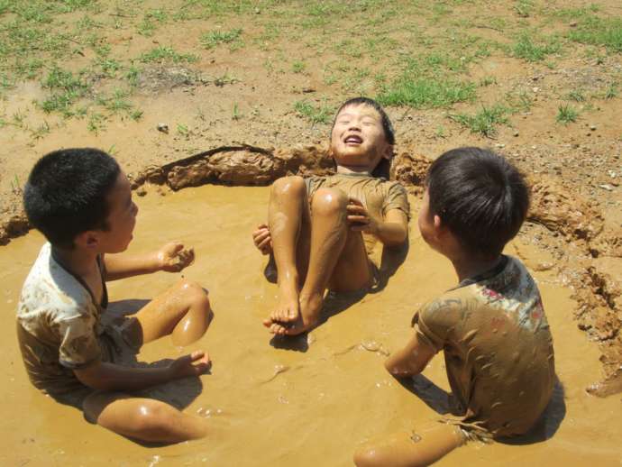 泥だらけになって遊ぶ子どもたち
