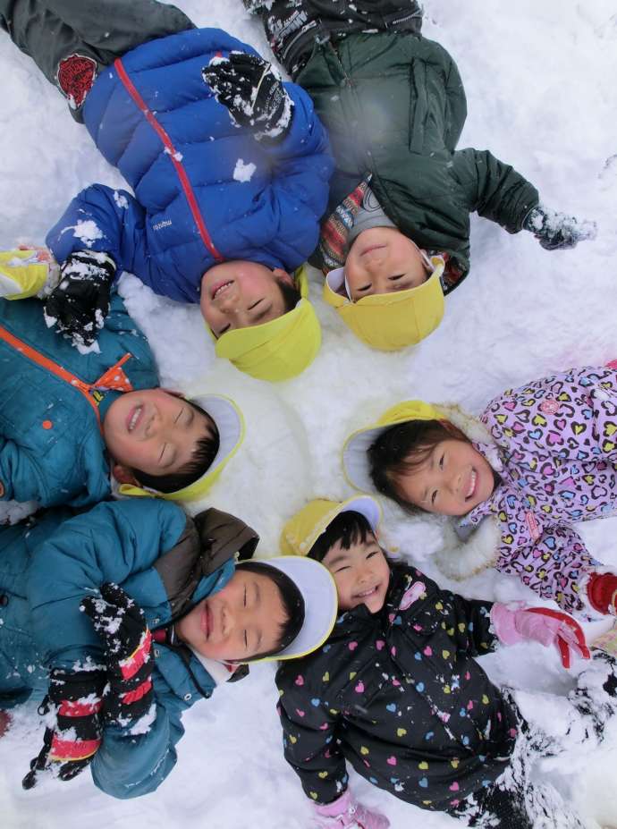 笑顔で雪遊びをする子どもたち