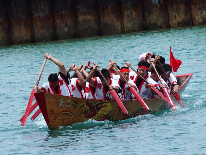 沖縄の伝統行事であるハーリーを行う男性たち