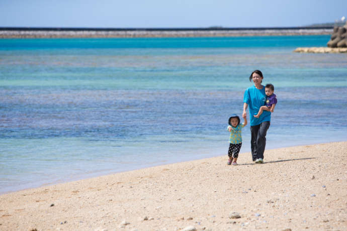 久米島のビーチを歩く母親と子ども