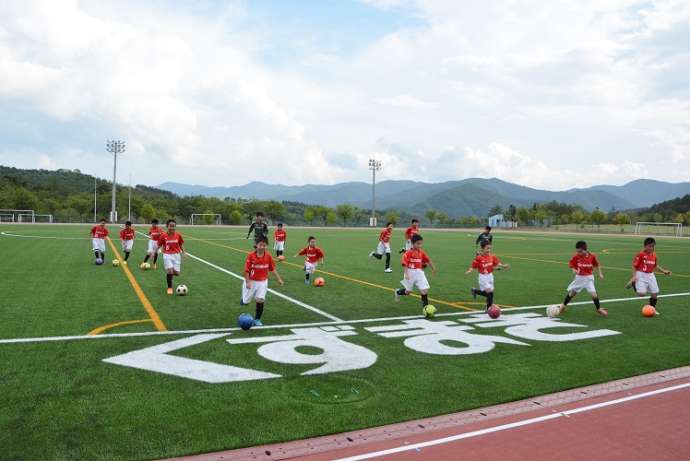 葛巻町総合運動公園人工芝グラウンドでサッカーをする子ども
