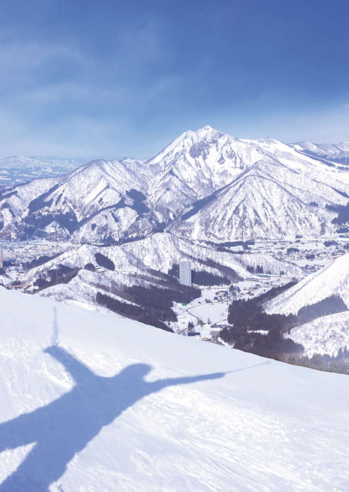 雪山とスキーを楽しむ人の影