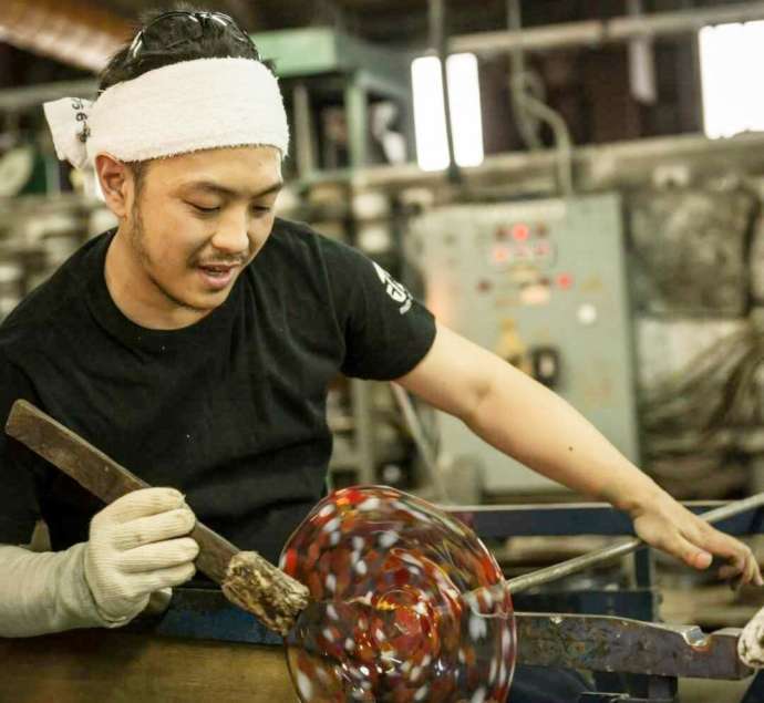 青森県青森市にある「津軽びいどろ」の工場で皿を作る様子