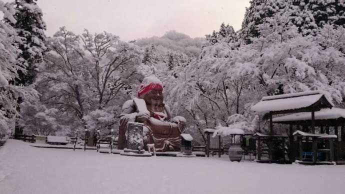 「通宝山彌勒寺」境内の巨大な布袋尊像と雪景色（冬）