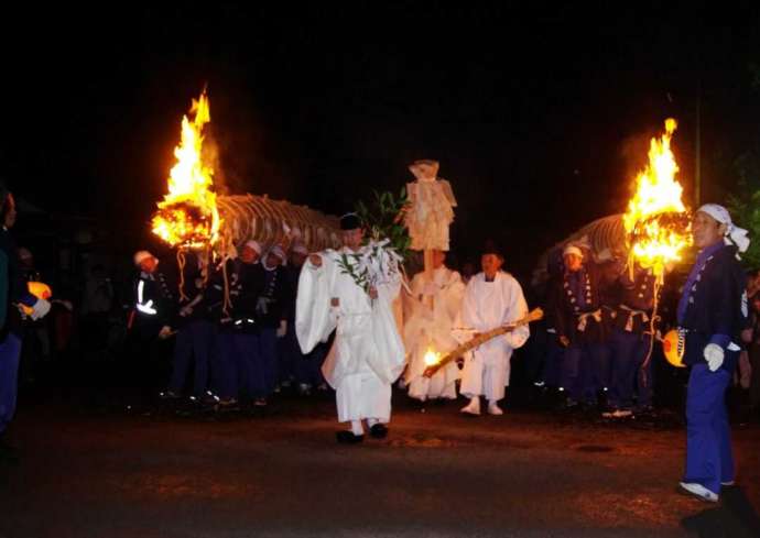 津島神社の開扉祭で炎の上がった大松明を担ぐ様子