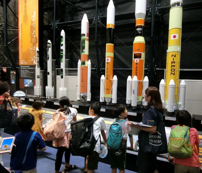つくば市にある筑波宇宙センター（JAXA）で展示解説を受ける子供たち