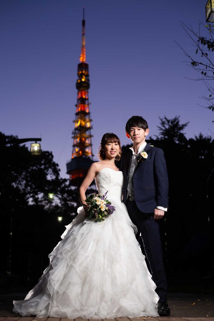 夜の東京タワーをバックにEMORIAでフォトウェディングに臨むカップル