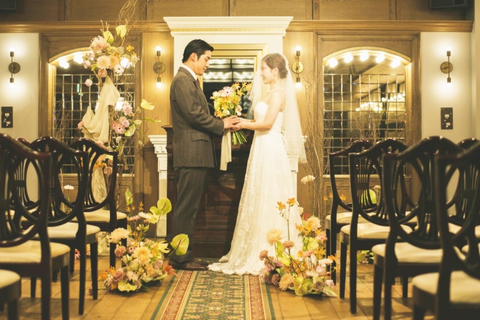 結婚式場で花束を抱えるカップル
