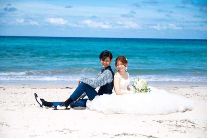 角島の砂浜で座って微笑む新郎新婦