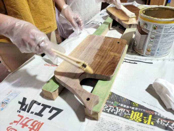 「アルブル木工教室」でのカッティングボード作りのワークショップの一コマ（オイルを塗布中）