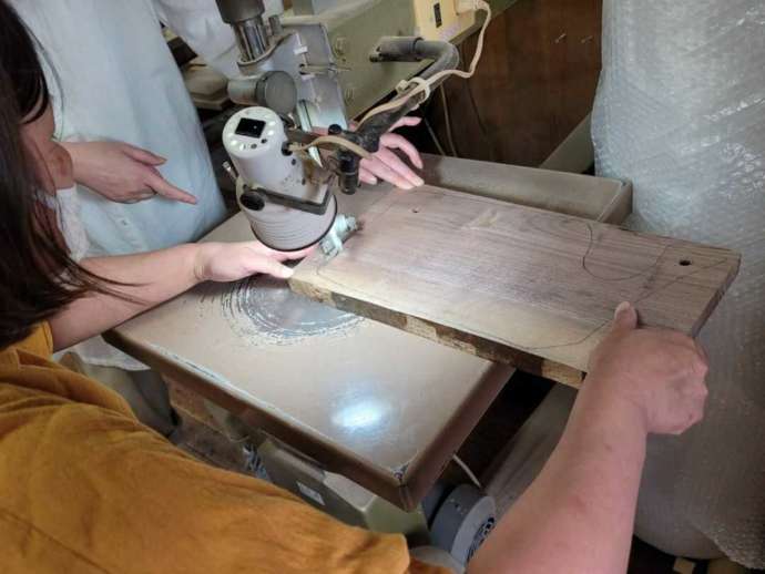 「アルブル木工教室」でのカッティングボード作りのワークショップの一コマ（電動糸鋸で木材をカット中）