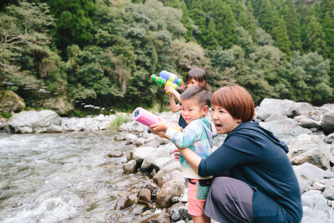 山江村の川で遊ぶ親子