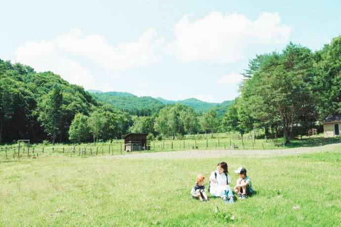 岐阜県飛騨市にある「天空の牧場 奥飛騨山之村牧場」の芝生でくつろぐ人たち