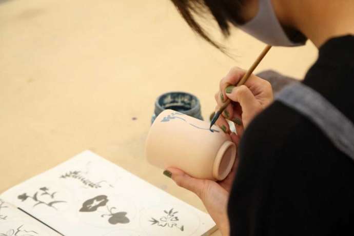 福岡県春日市にある「陶芸教室やわら木」で絵付け体験をしている女性