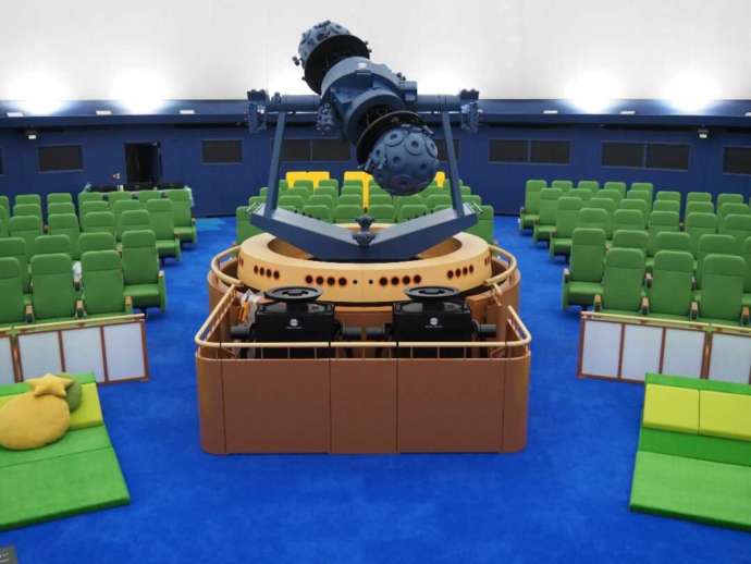 プラネタリウムドームの投影機と座席の写真