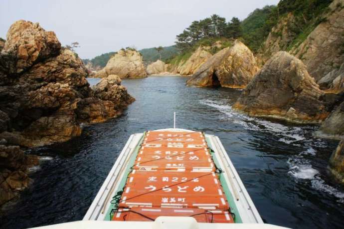 浦富海岸島めぐり遊覧船が岩の間を進む様子