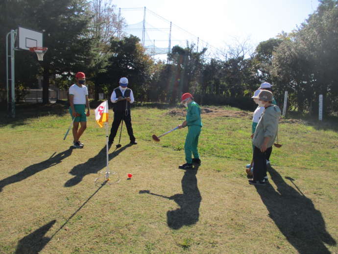 グランドゴルフをする小学生と地域の大人