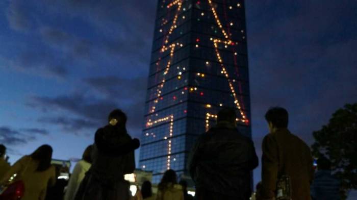 千葉県にあるポートタワーのクリスマスイルミネーションを眺めるイベント参加者たち