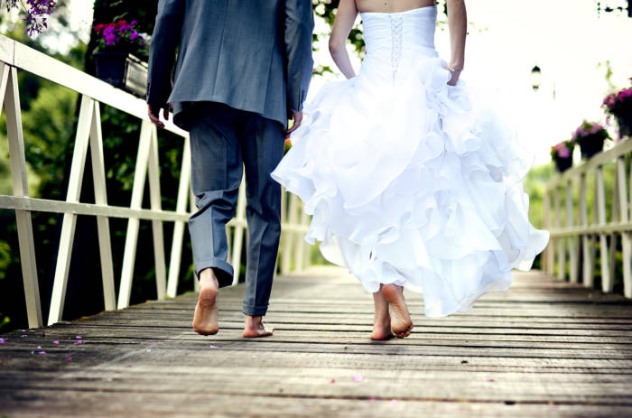 橋を歩く成婚カップルのイメージ写真