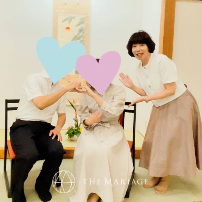 成婚者と写真に収まる「婚活サロン テマリアージュ」代表の志茂淳子さん