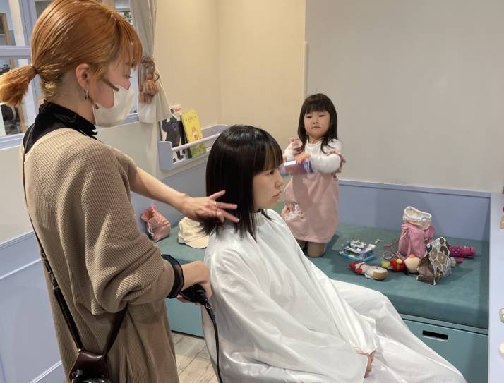 東京都世田谷区の美容室・アコットでヘアカット中のママの様子を見つめる女の子