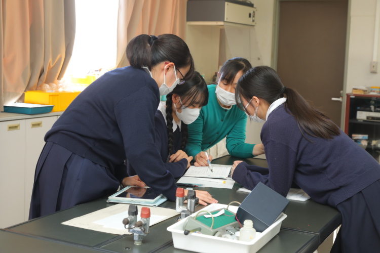 愛徳学園中学校・高等学校の理科室で先生から指導を受ける生徒たち