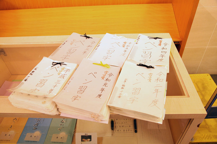 文京学院大学女子中学校の生徒による1年分のペン習字を綴った紙の束