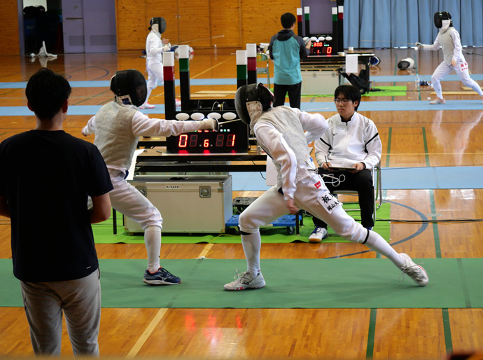 岡山大安寺中等教育学校のフェンシング部の生徒が試合をするようす