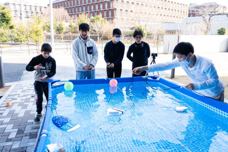 「水中ロボット制作ラボ」の生徒らがロボットを操作するようす