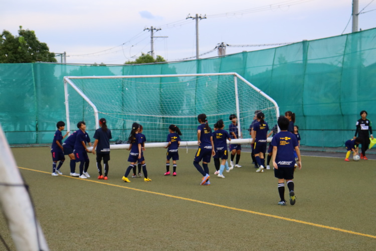協力してサッカーゴールを移動させるASハリマアルビオンジュニアの生徒たち