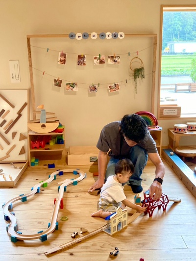 福井県池田町の「あそびハウスこどもと森」で木のおもちゃで遊ぶ親子